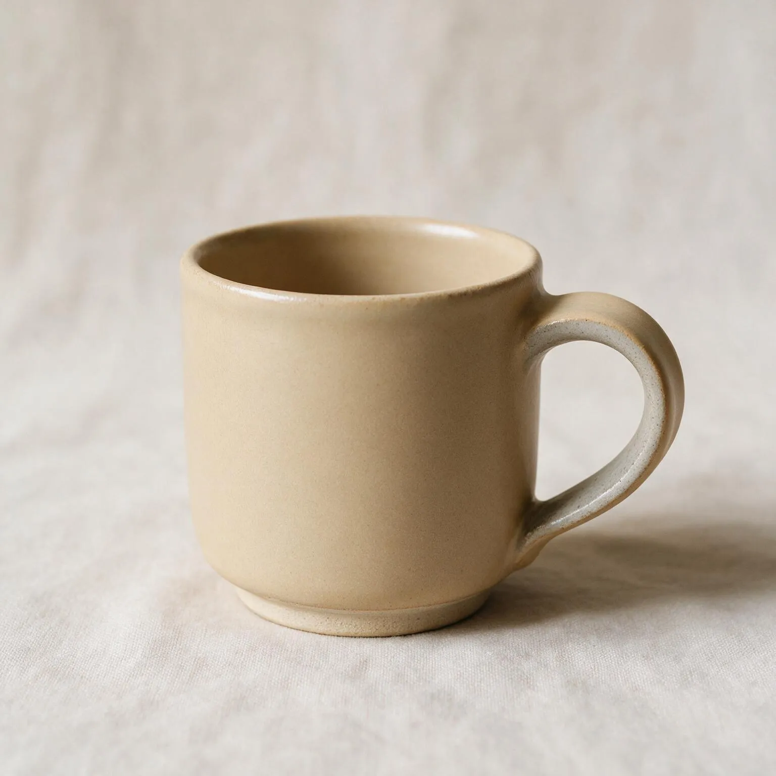 Steinzeugbecher mit sandfarbener matter Glasur