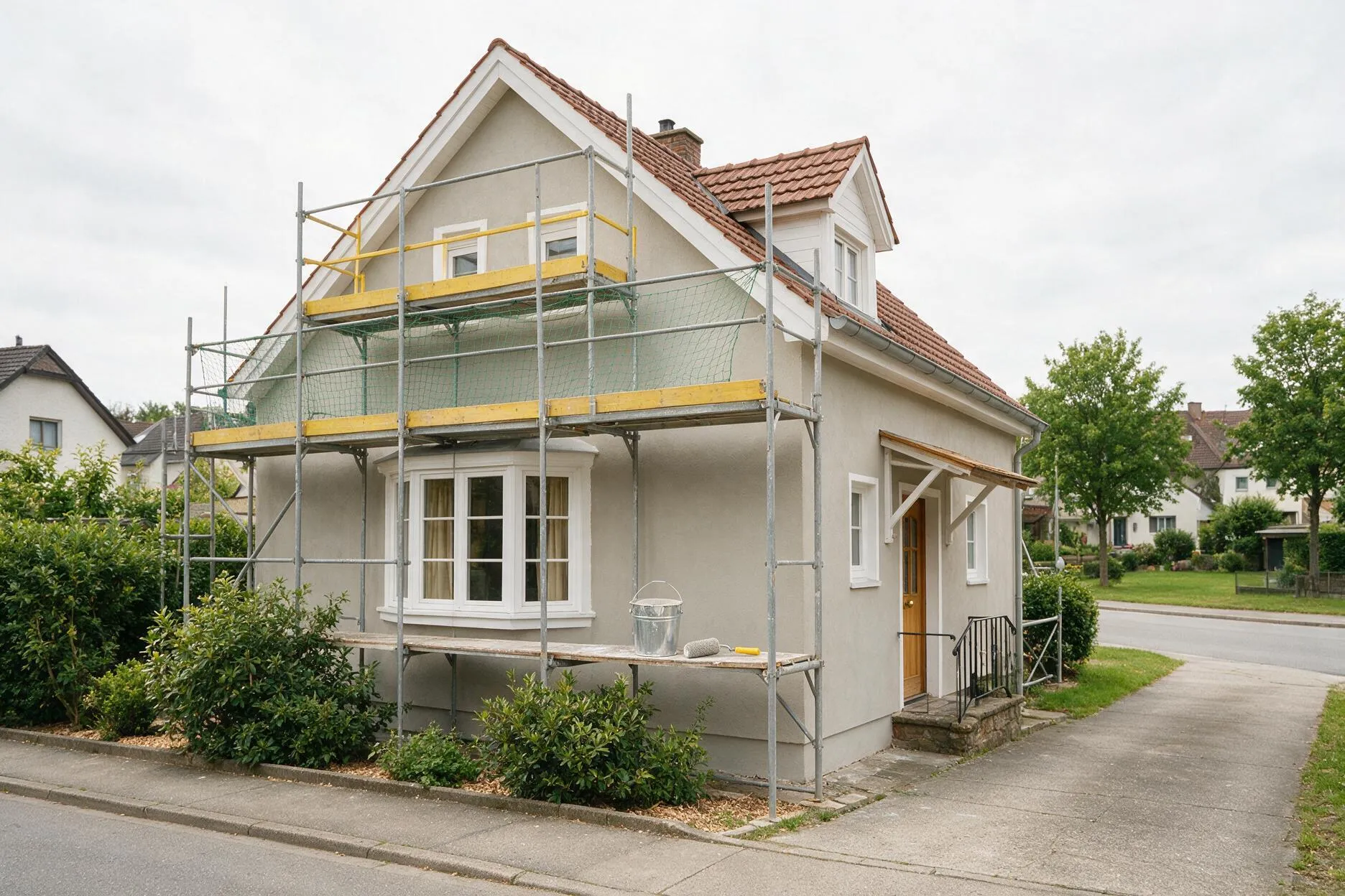 Eingerüstete Hausfassade mit frischem hellgrauem Anstrich